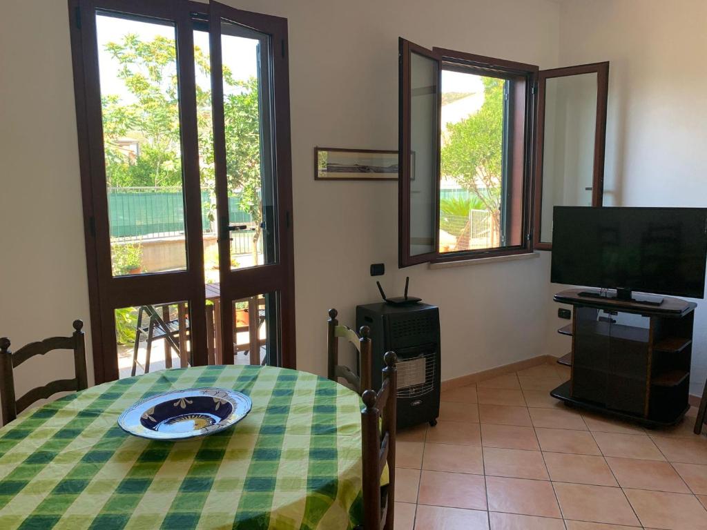 博萨A Casa di Nonna的客厅配有桌子、电视和电视。