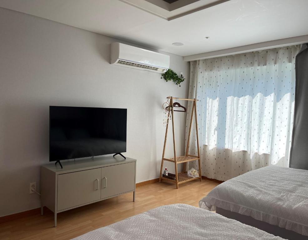 首尔Hongdae Residence 3 - 1min from Hongik Uni station Exit #1的一间卧室设有平面电视和一张床。