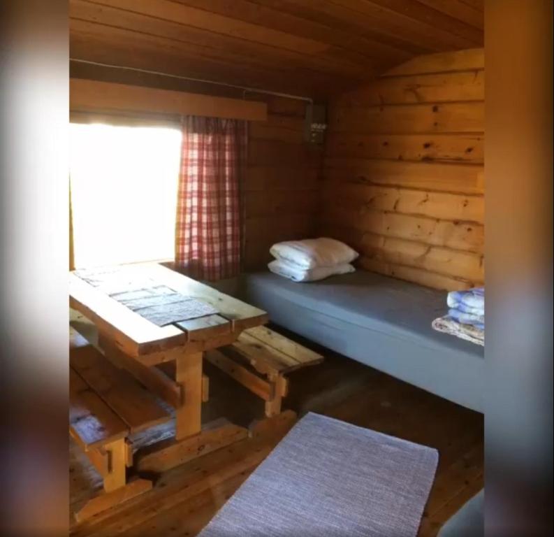 埃农泰基厄Lätasenonmajat的小屋内带床和桌子的房间