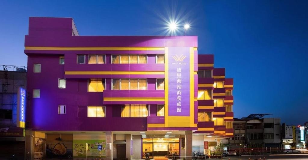 埔里埔里西站旅馆的紫色的建筑,上面有灯