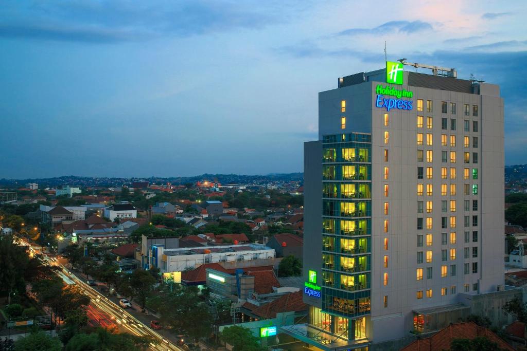 三宝垄三宝垄新邦利马快捷假日酒店的上面有绿色标志的高楼
