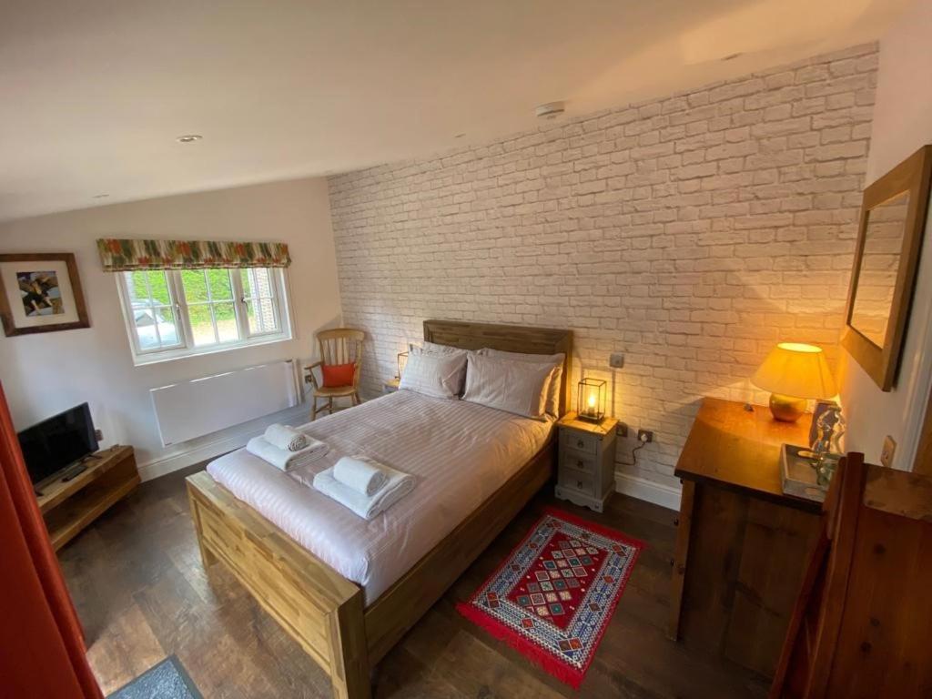 欧卡里Nightjar的一间卧室设有一张大床和砖墙