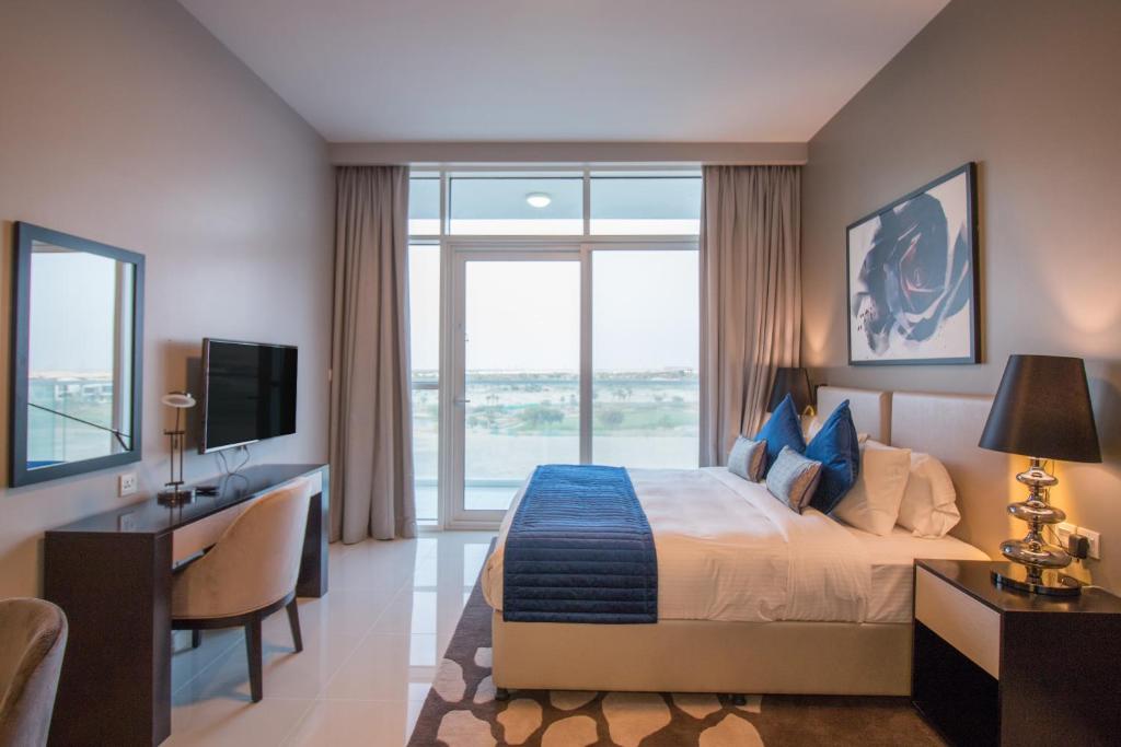 迪拜Premium Studio with Beautiful Golf Course View的一间卧室配有一张床、一张书桌和一台电视