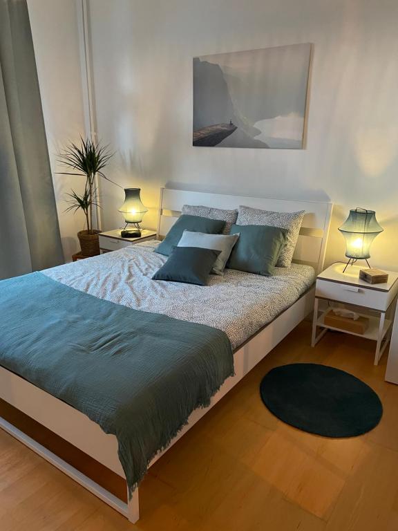 布鲁塞尔Appartement de charme dans maison de maître bruxelloise的一间卧室配有一张带蓝色枕头的大床