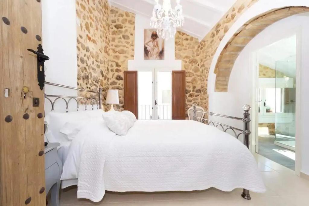 LliberCasa Rural Lliber的卧室配有白色的床和石墙