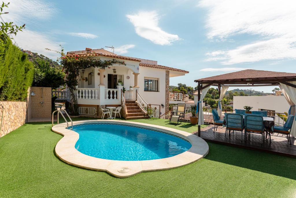 罗列特海岸Villa Maria的一个带游泳池和房子的后院