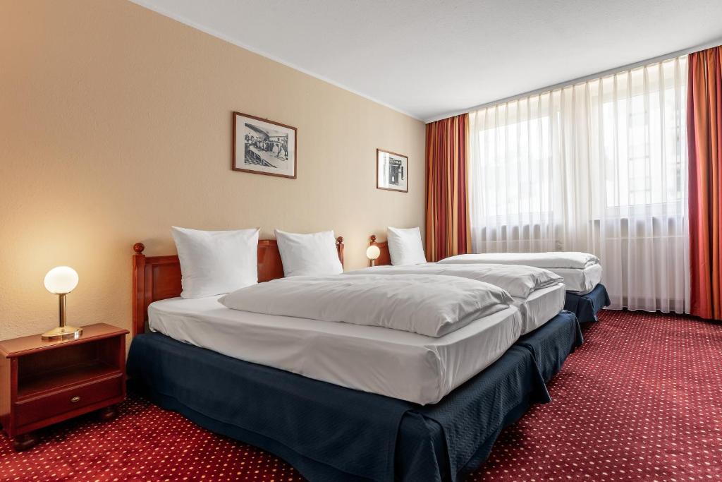 纽伦堡纽伦堡阿兹姆酒店的酒店客房设有两张床和窗户。
