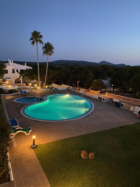 桑帕克Gin&Tonic Apartment的度假村在夜间提供大型游泳池
