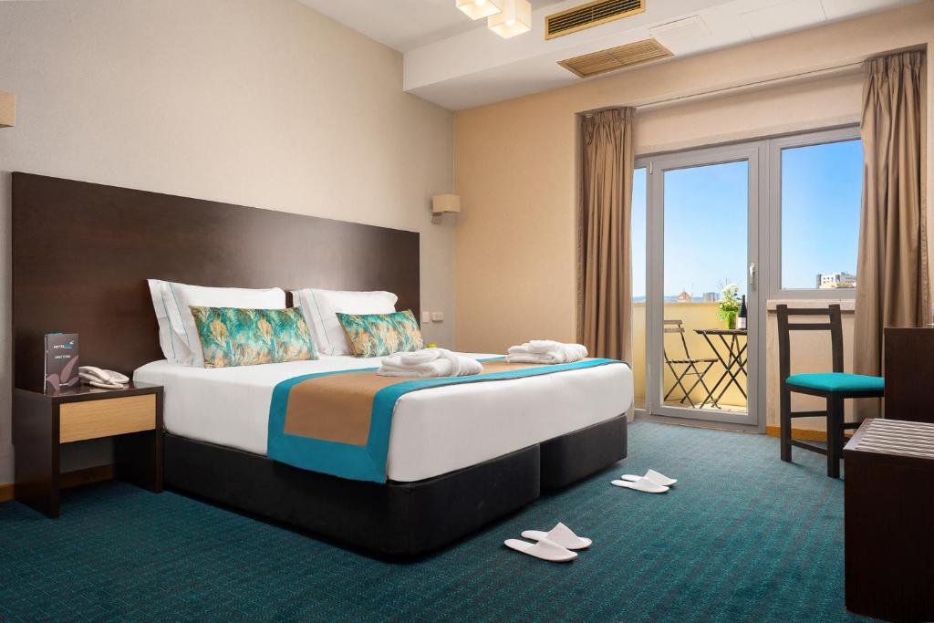 里斯本DAH酒店 - 多姆阿丰索亨利克斯的酒店客房设有一张大床和一个阳台。