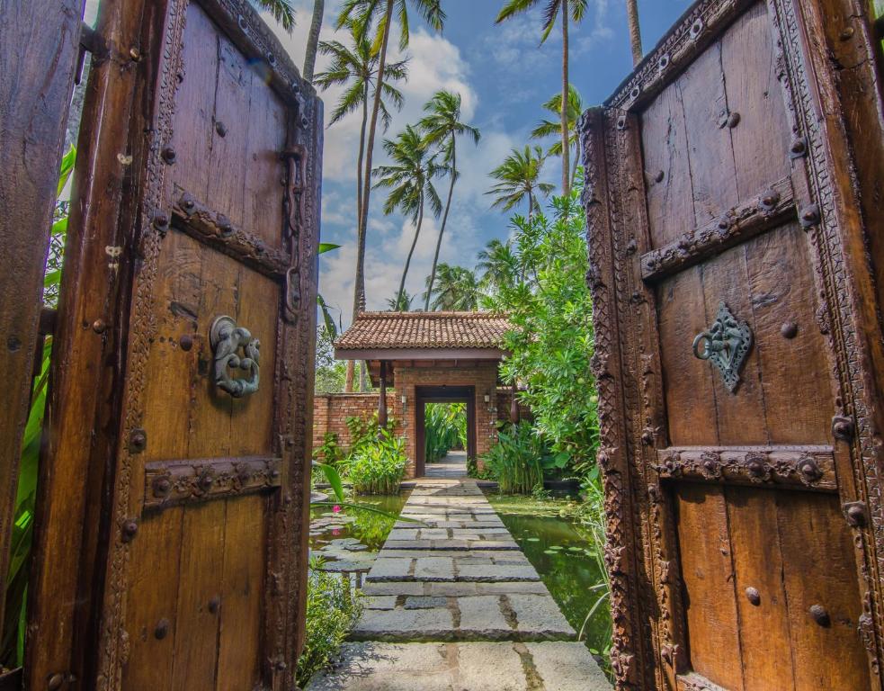 瓦都瓦Reef Villa的拥有两扇木门的房子的入口