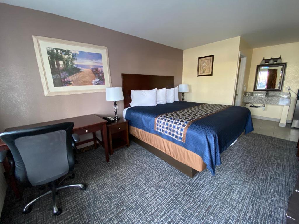 阿罗约格兰德海滩路酒店的酒店客房配有一张床、一张桌子和一把椅子。
