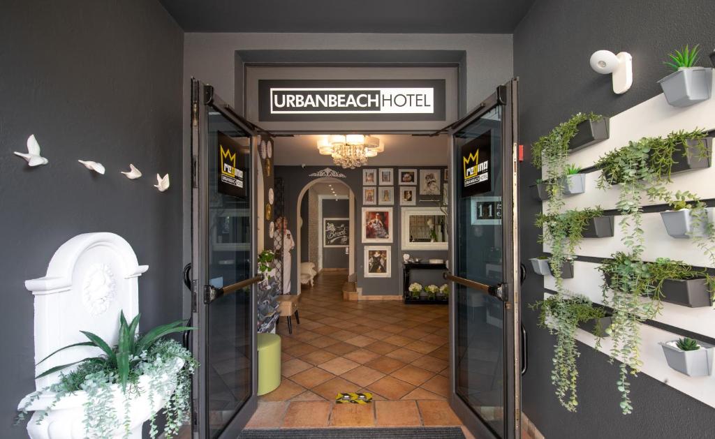 利多迪耶索罗Regina Urban Beach Hotel的通往墙上植物的房间的敞开的门