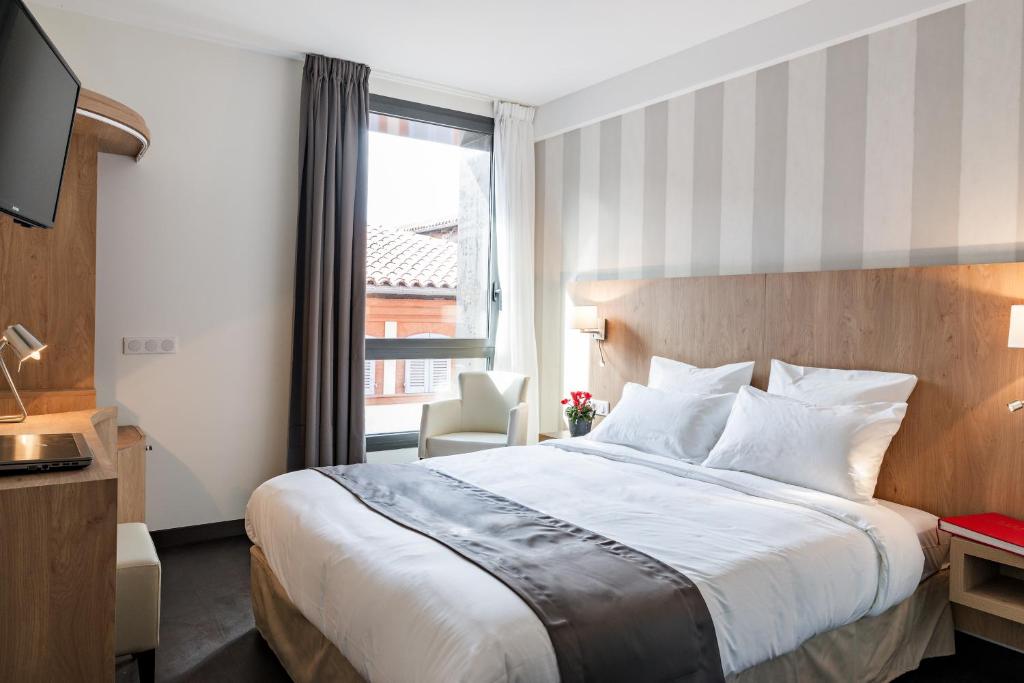 图卢兹乐佩雷莱昂酒店的一间设有大床和窗户的酒店客房