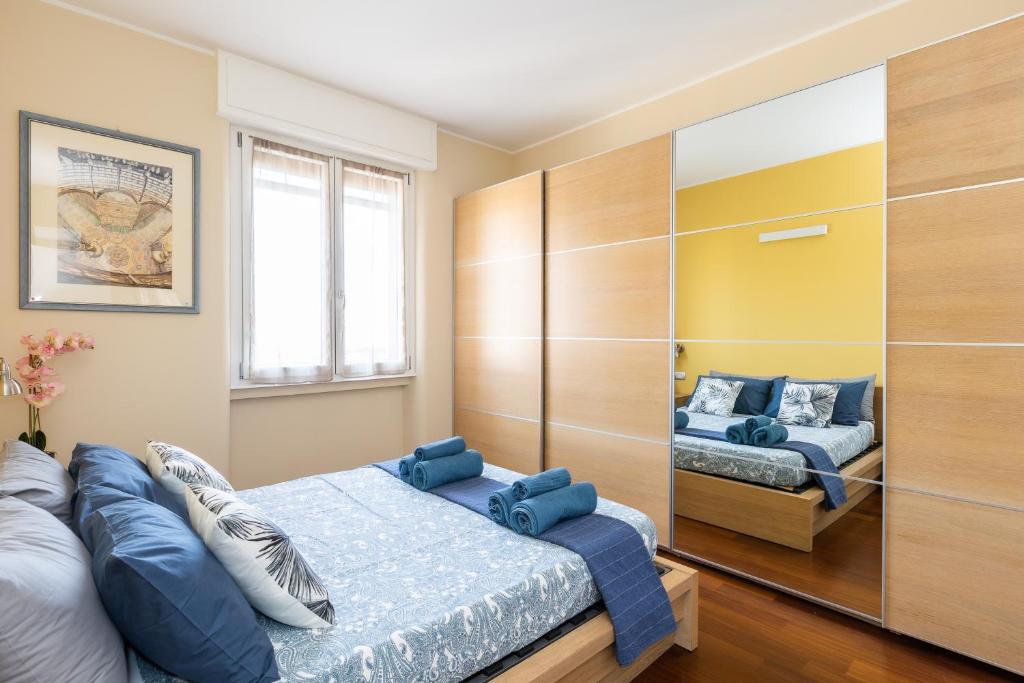 米兰Rosselli 13 Milan Apartment的一间卧室配有两张带蓝色枕头的床