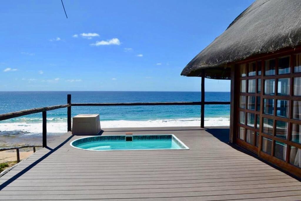 伊尼扬巴内Mozambique,Inhambane,Barra -Entire Beach House的海滩上带小型游泳池的木甲板