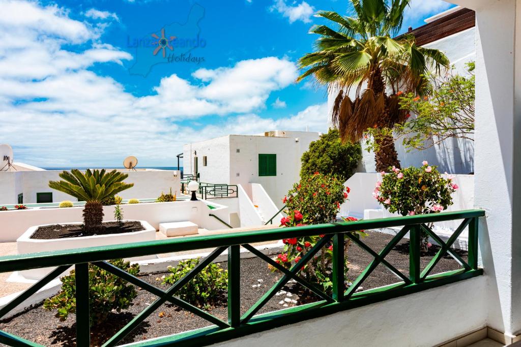 卡门港Vivienda Vacacional Casa Evy的享有海滩和棕榈树景致的阳台