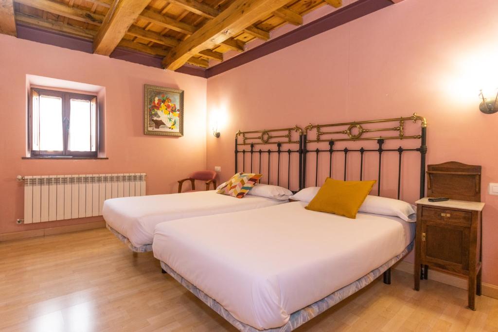 Prádanos de OjedaHotel Rural Fuente del Val的一间卧室设有两张床和窗户。