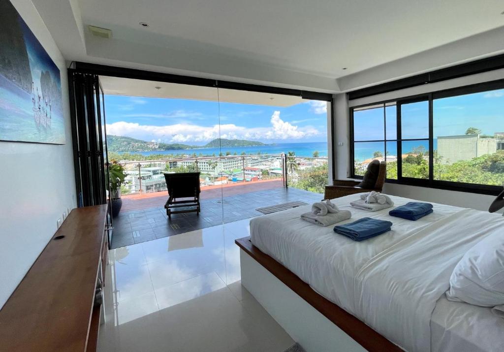 芭东海滩Andaman Hills - panoramic sea view house in Patong的一间卧室设有一张床,享有海景