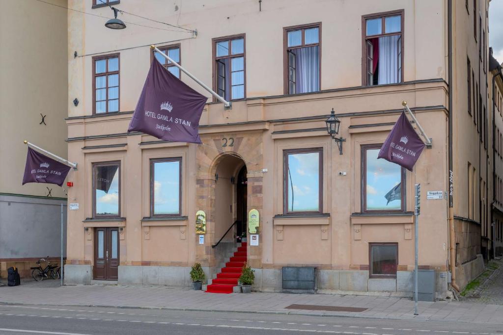斯德哥尔摩Hotel Gamla Stan, BW Signature Collection的前面有两面紫色旗帜的建筑