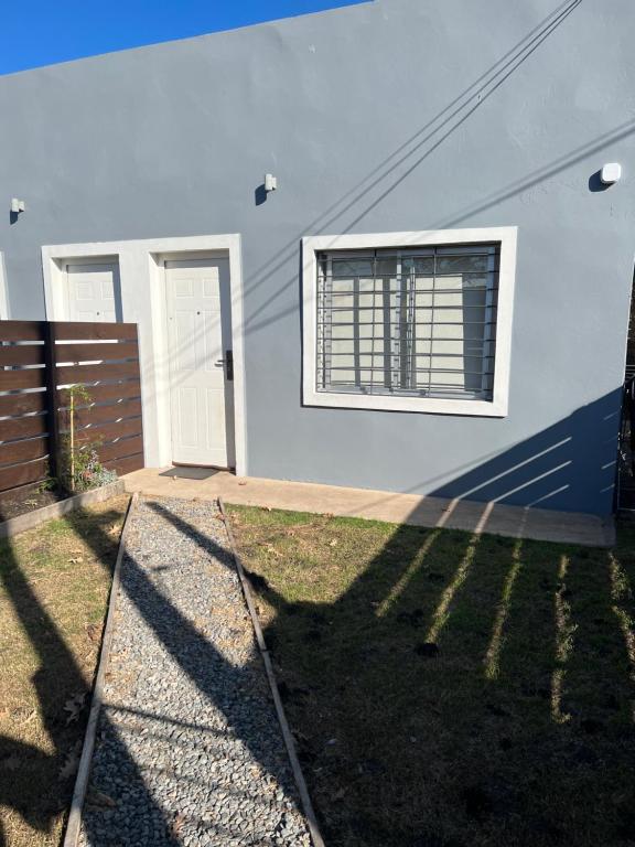 派桑杜Apart del Este 2的白色的房子,设有窗户和栅栏