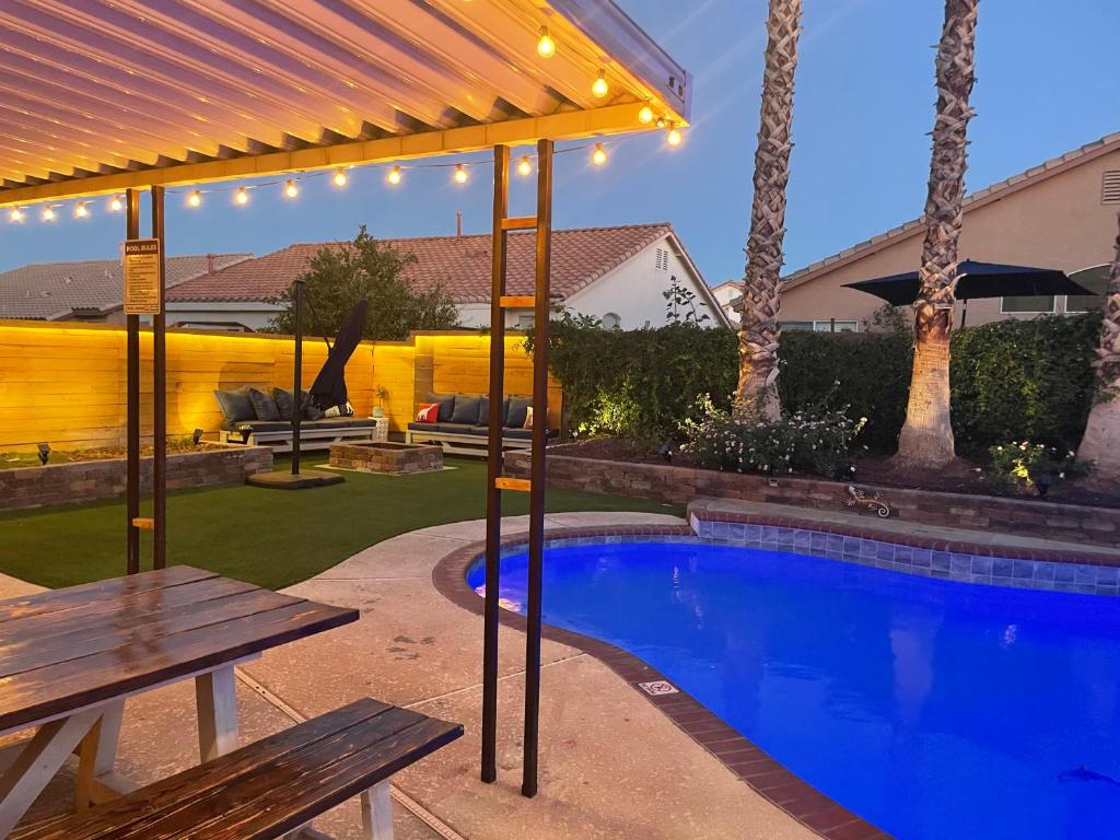 拉斯维加斯Gorgeous Henderson Home with Pool!的后院设有游泳池和野餐桌