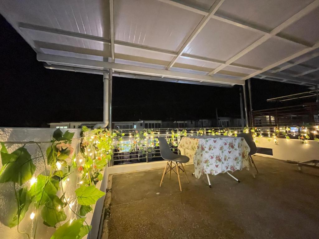 浮罗山背Homestay Balik Pulau的夜间阳台上的桌椅