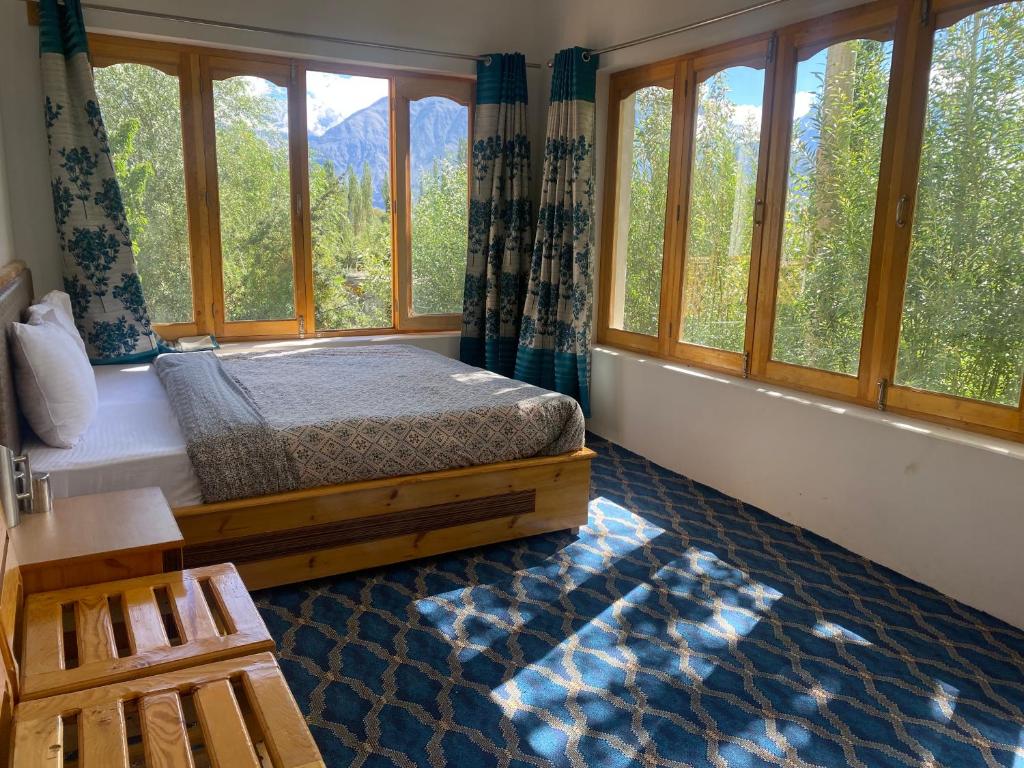 DeskitOtsal guest house nubra的一间卧室设有床铺和树木窗户