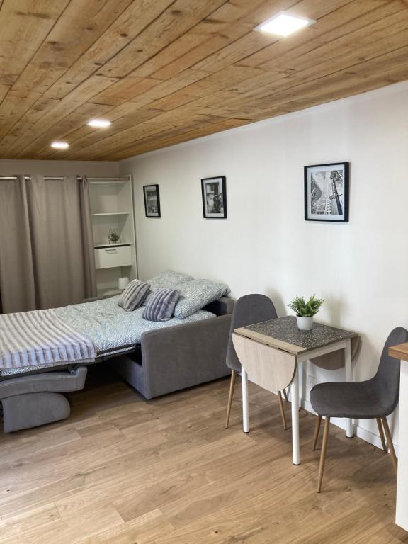 舒瓦西勒鲁瓦Affaires ou Loisirs - La Cachette Secrete的卧室配有一张床和一张桌子及椅子