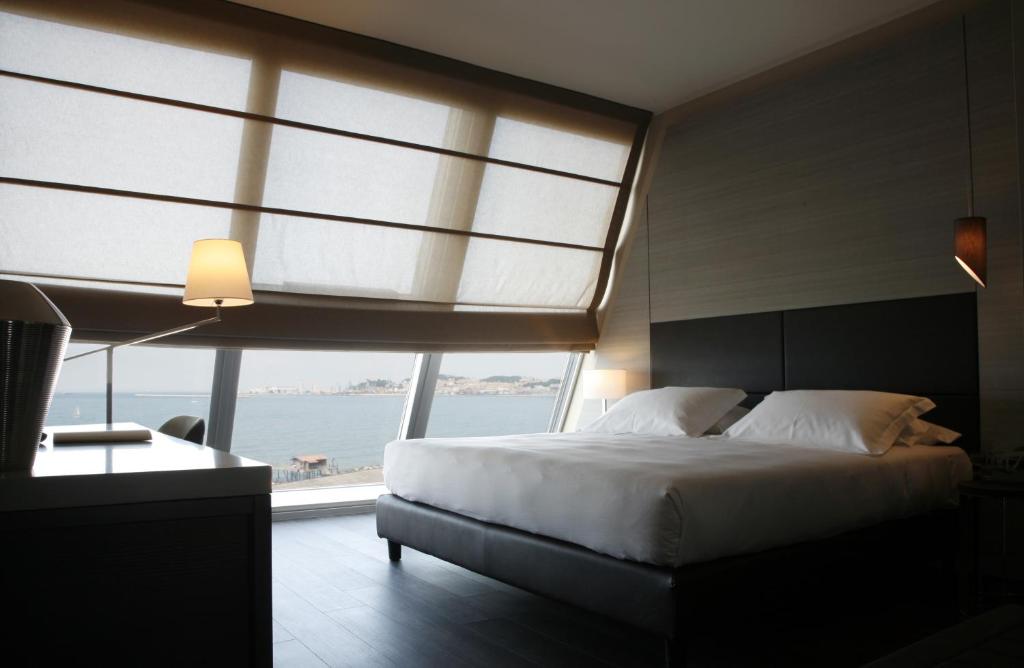 安科纳伊戈酒店的一间卧室设有一张大床和一个大窗户
