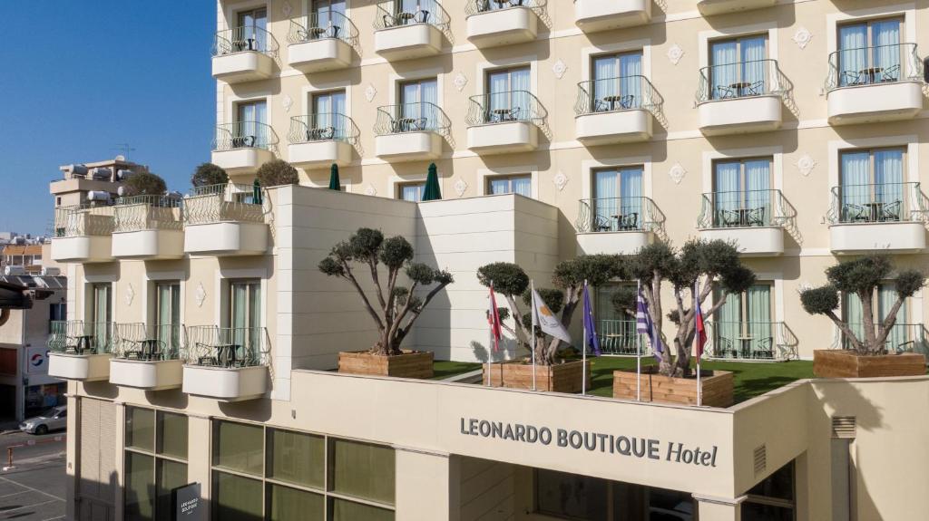 拉纳卡Leonardo Boutique Hotel Larnaca的外墙上种有盆栽树木的酒店