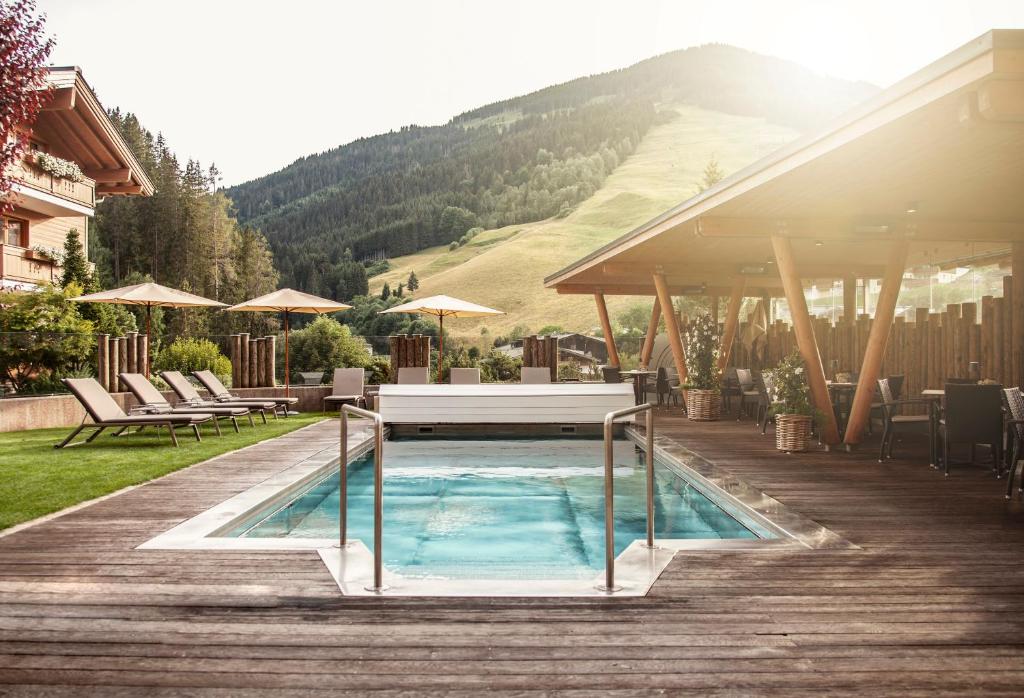 萨尔巴赫索奈格酒店的木制甲板上的带桌子的游泳池