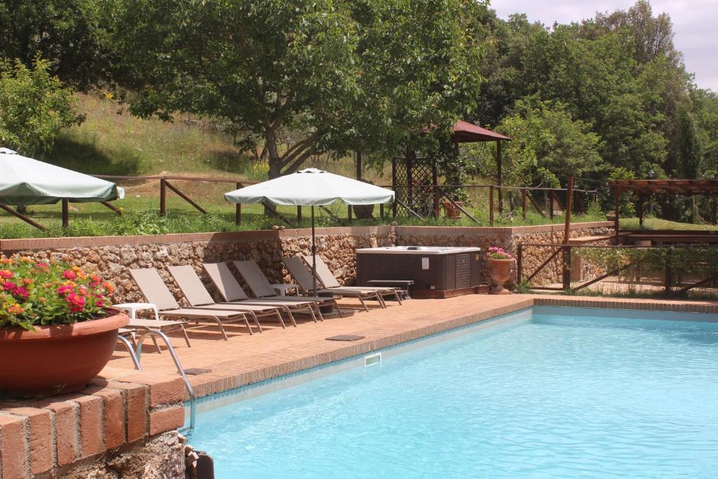 索维奇勒Podere Casetta Entire Property的游泳池旁设有椅子和遮阳伞