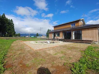 猪苗代町Guest House Inawashiro~Hanbog~的建筑物旁田野的房子