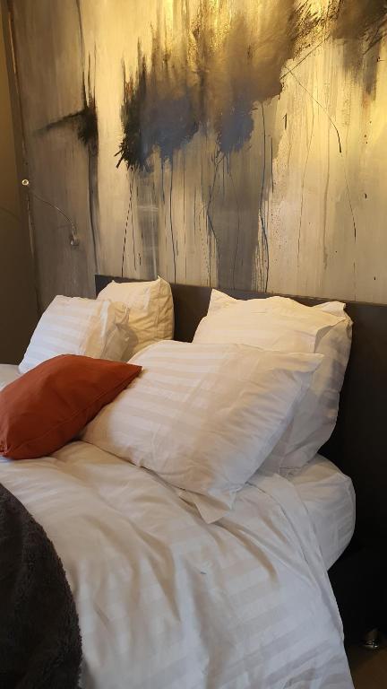 艾姆波茨卡佩尔gîte Artbnb的卧室内的一张带白色床单和枕头的床