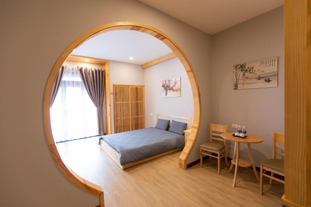 大叻Nguyễn Tài Hostel & Coffee Đà Lạt的一间卧室配有床和圆镜子