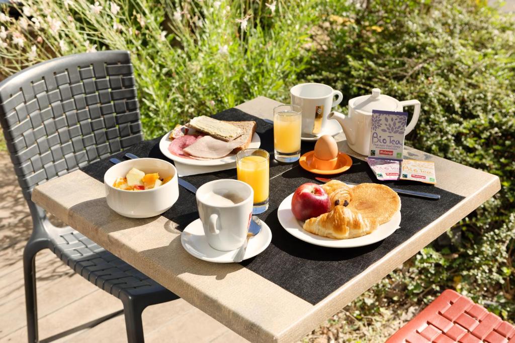 维特罗勒马赛普罗旺斯区机场基里亚德酒店的一张桌子,上面有早餐食品和饮料