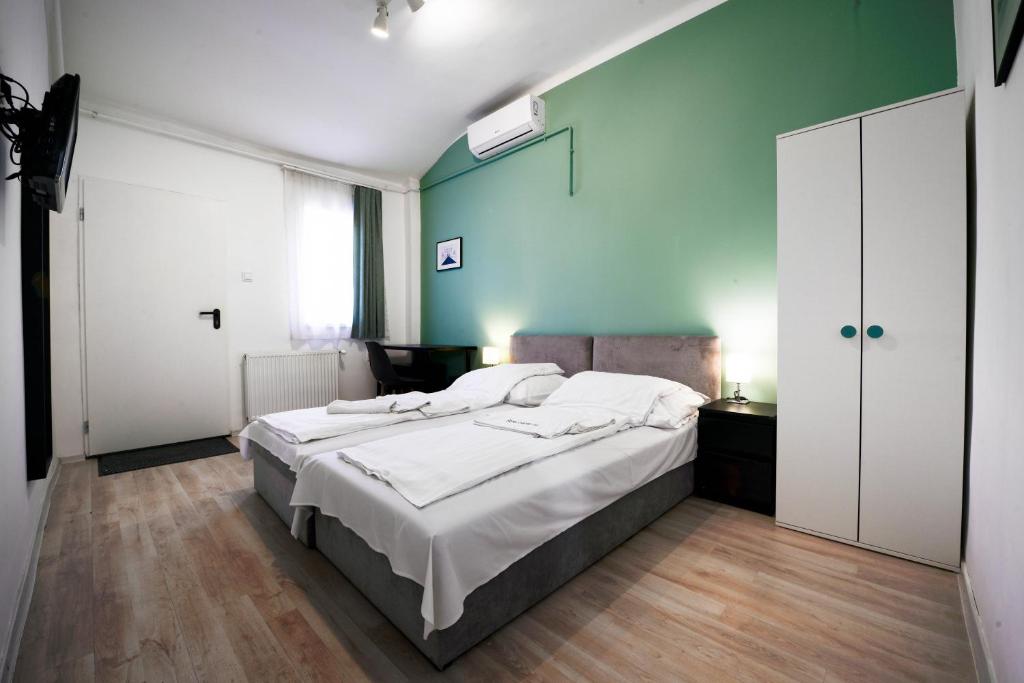 布达佩斯切斯康姆旅馆的一间卧室设有一张大床和绿色的墙壁