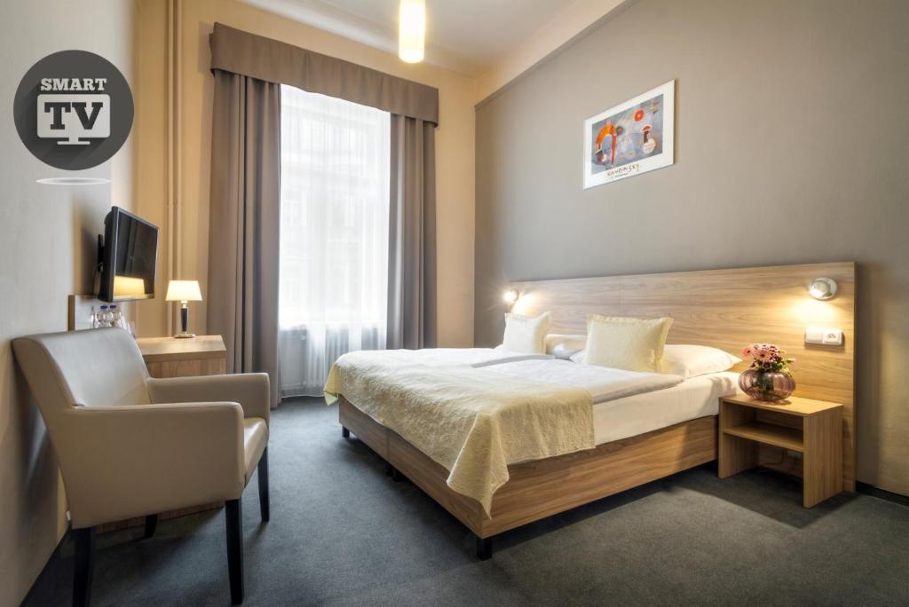 布拉格大西洋酒店的配有一张床和一把椅子的酒店客房