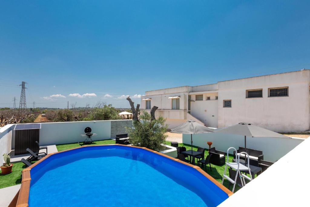 卡萨拉诺Villa Amaltea by BarbarHouse的一座带建筑物的房屋后院的游泳池