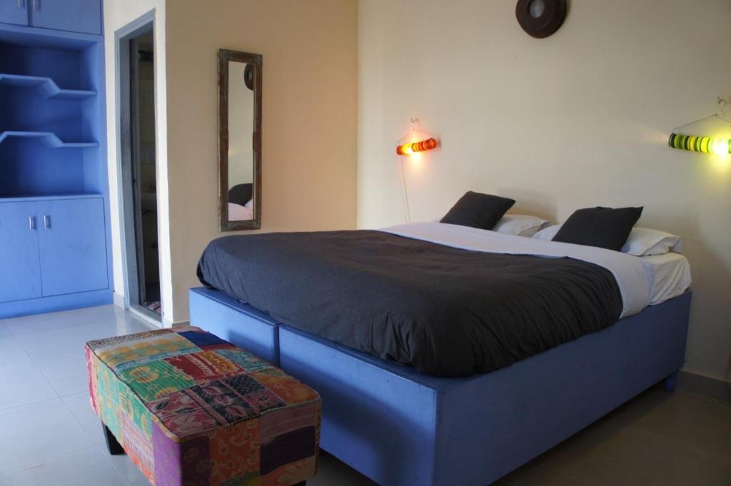 新德里Bed & Chai Guesthouse的一间卧室配有一张蓝色框的大床