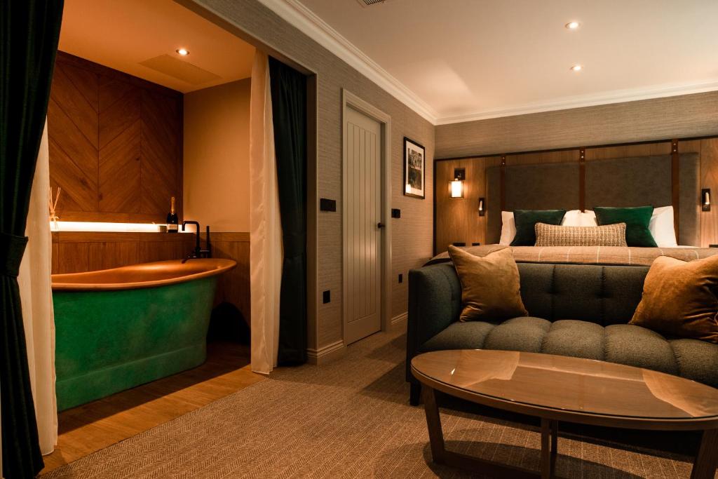 阿什伯恩Stables Ashbourne的酒店客房配有床、沙发和桌子。