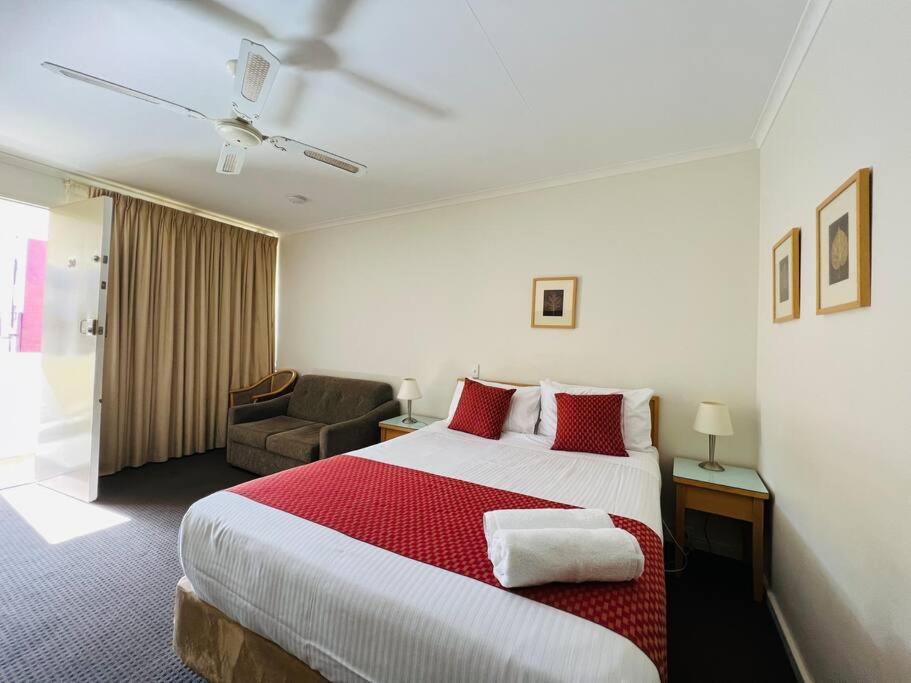 格莱内尔格1BR at Moseley st Glenelg 30的酒店客房带一张大床和一把椅子