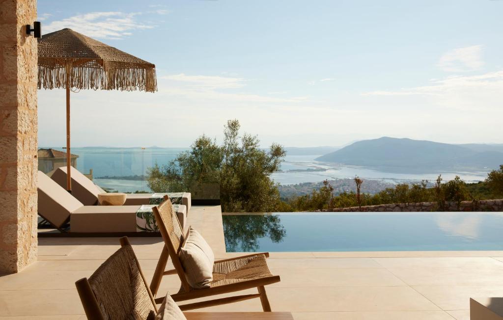 苏卡雷斯Epiphany Villas Lefkada的一个带游泳池和椅子的度假村,享有美景