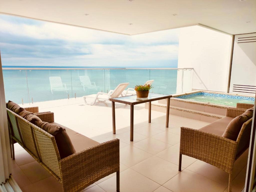 通苏帕Departamentos frente al mar Resort Playa Azul的阳台配有桌子,享有海景。
