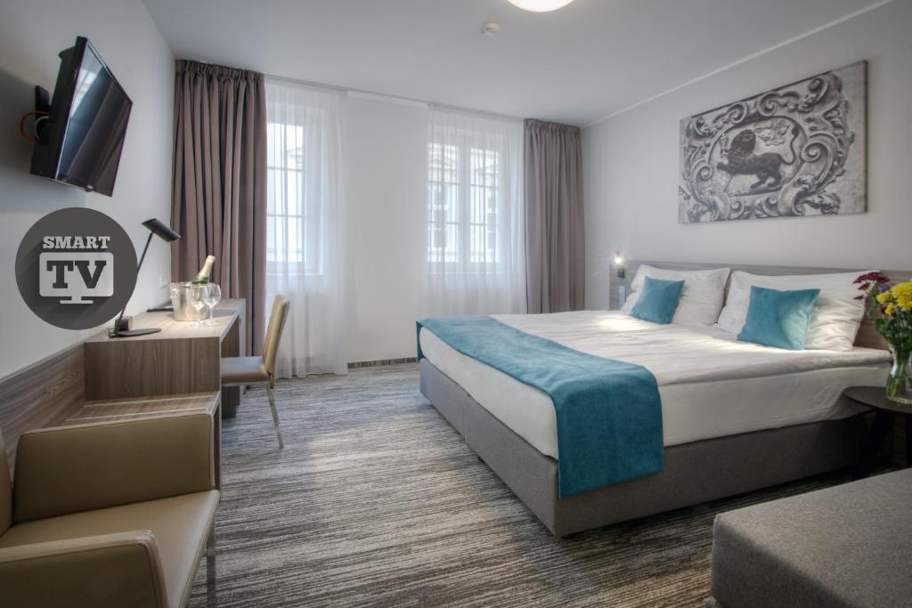 布拉格帕夫酒店的酒店客房设有一张大床和一张书桌。