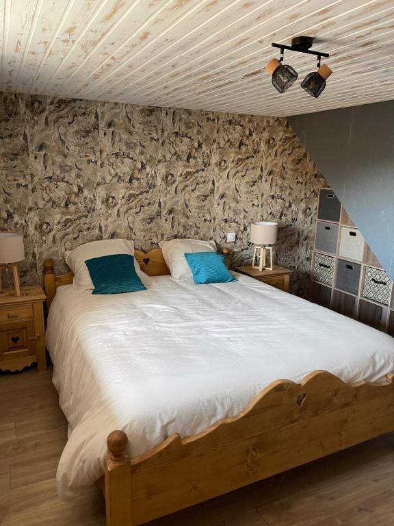 MontperreuxCHALET-MICHEL avec SPA的一间卧室配有一张带蓝色枕头的大型木制床。
