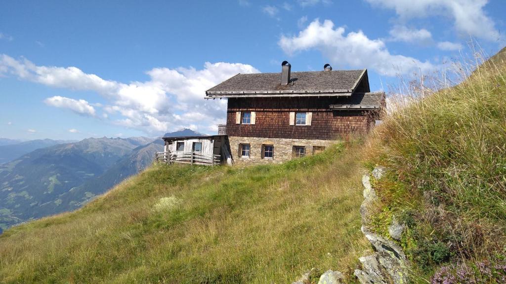圣莱奥纳尔多因帕西里亚Almgasthaus Flecknerhütte的草山边的房子