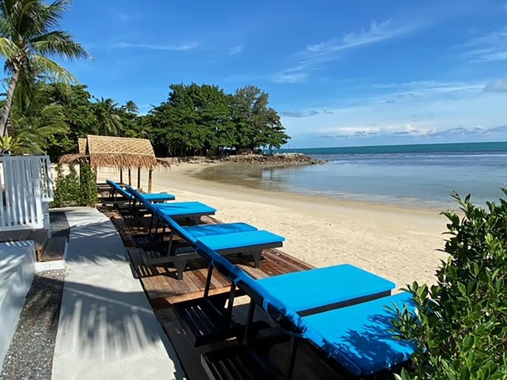 班邦宝Nam Jai Beach - Sunset的海滩上的一排蓝色桌子