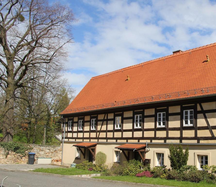 MüglitztalFachwerkhaus Maxen的一座黑色和白色的建筑,拥有橙色的屋顶