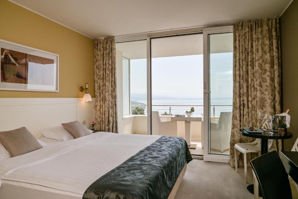 奥帕提亚Hotel Laurus - Liburnia的酒店客房设有一张床和一个大窗户